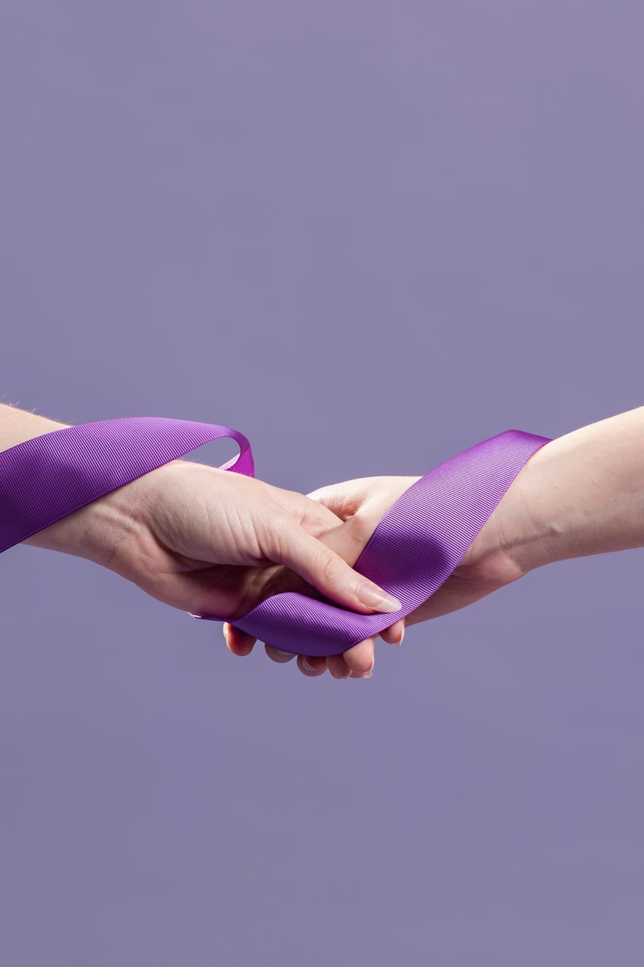 Deux mains tenant un ruban violet